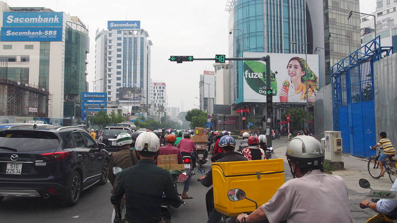 Cidade de Ho Chi Minh em Vietnã - Trânsito de carro e motos em HCMC